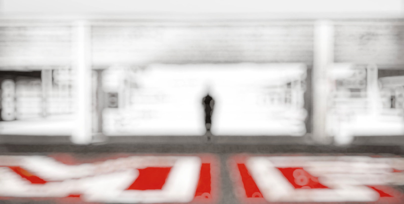 A lone figure at the end of a long white corridor